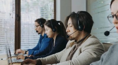 Group of people sitting in front of their working PCs.